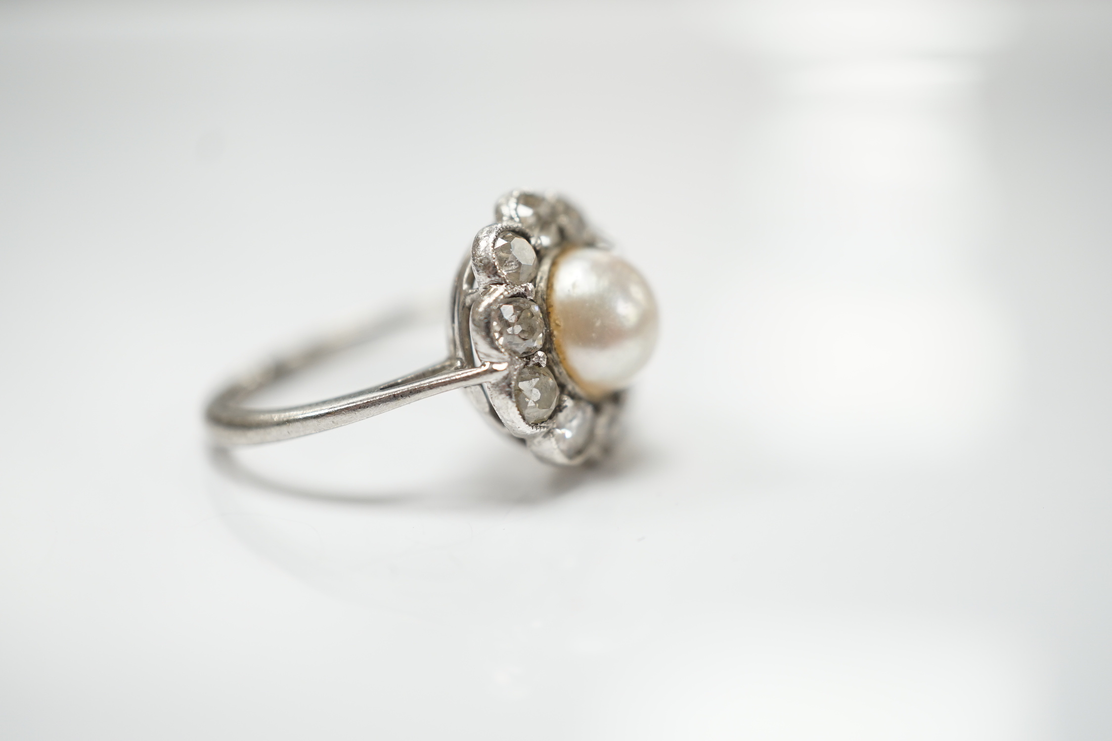 A white metal (stamped Pall) cultured pearl and diamond set circular cluster ring, size L, gross weight 3.3 grams.